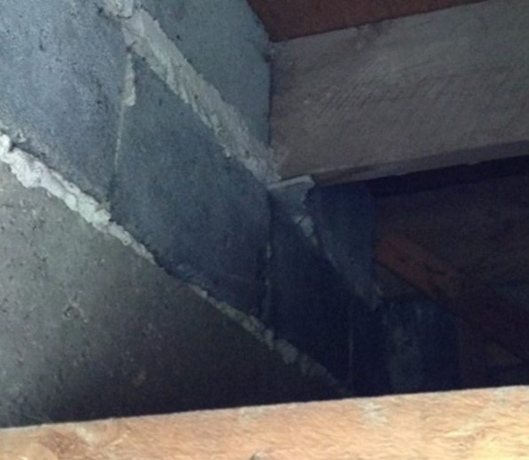 Image of an AIB packer coming out from a top row of brick wall below a timber joist