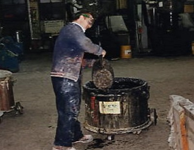 person pouring chemical into large container