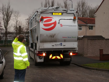 A waste collector using reversing assistant training (back view)