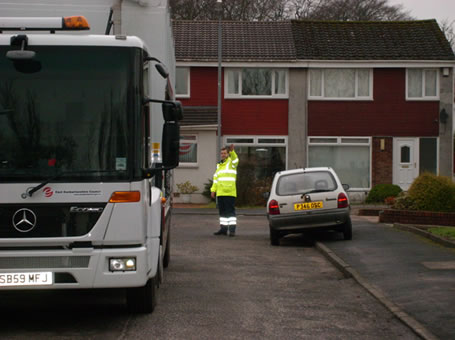 A waste collector using reversing assistant training (front view)