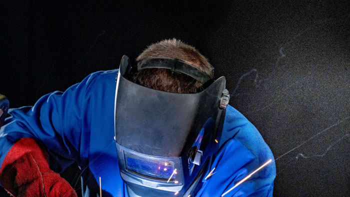 Person with face shield welding