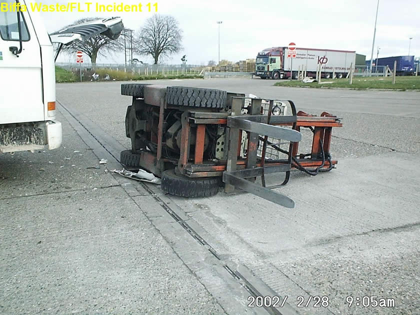 Fork lift truck on its side next to front of truck with accident damage